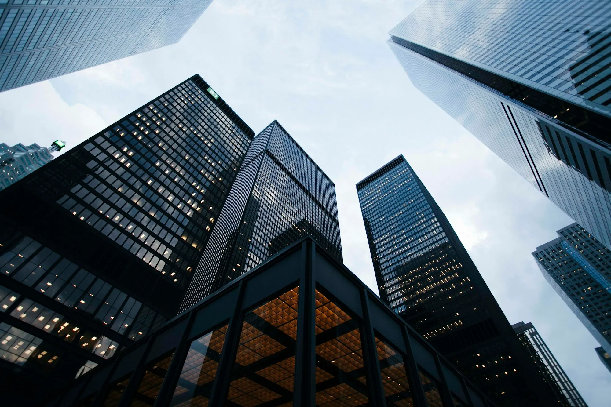 Reflective glass-and-steel office towers rising against an overcast sky.